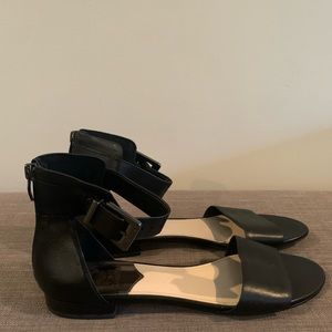 Vince Camuto black leather flat sandals with ankle strap.